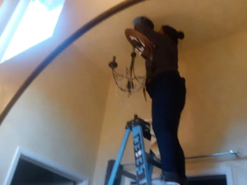 Electrician installing a chandelier in a Burlingame residence